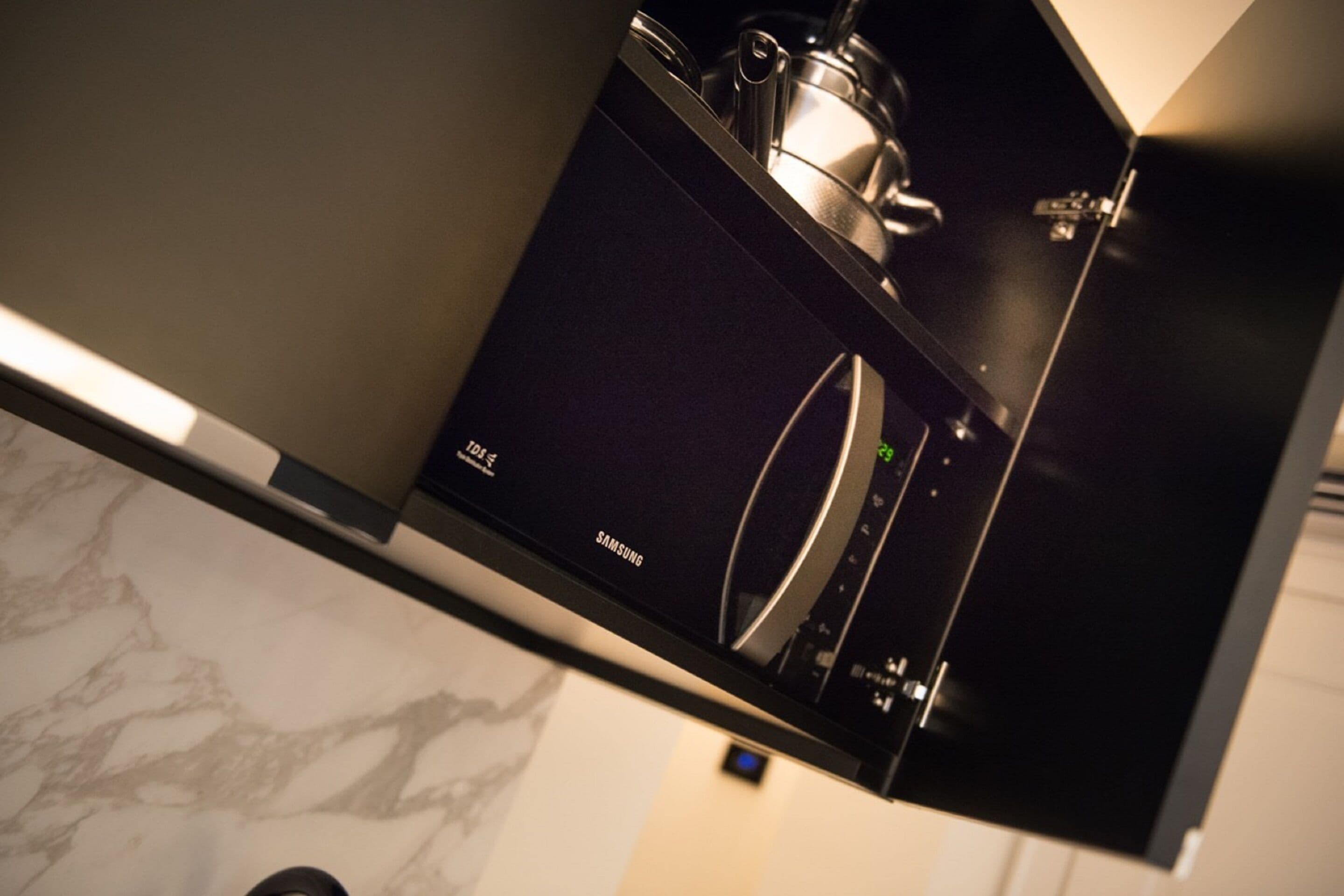 Un réfrigérateur Samsung doté d’un écran numérique, d’un distributeur d’eau en acier inoxydable et d’un extérieur noir.