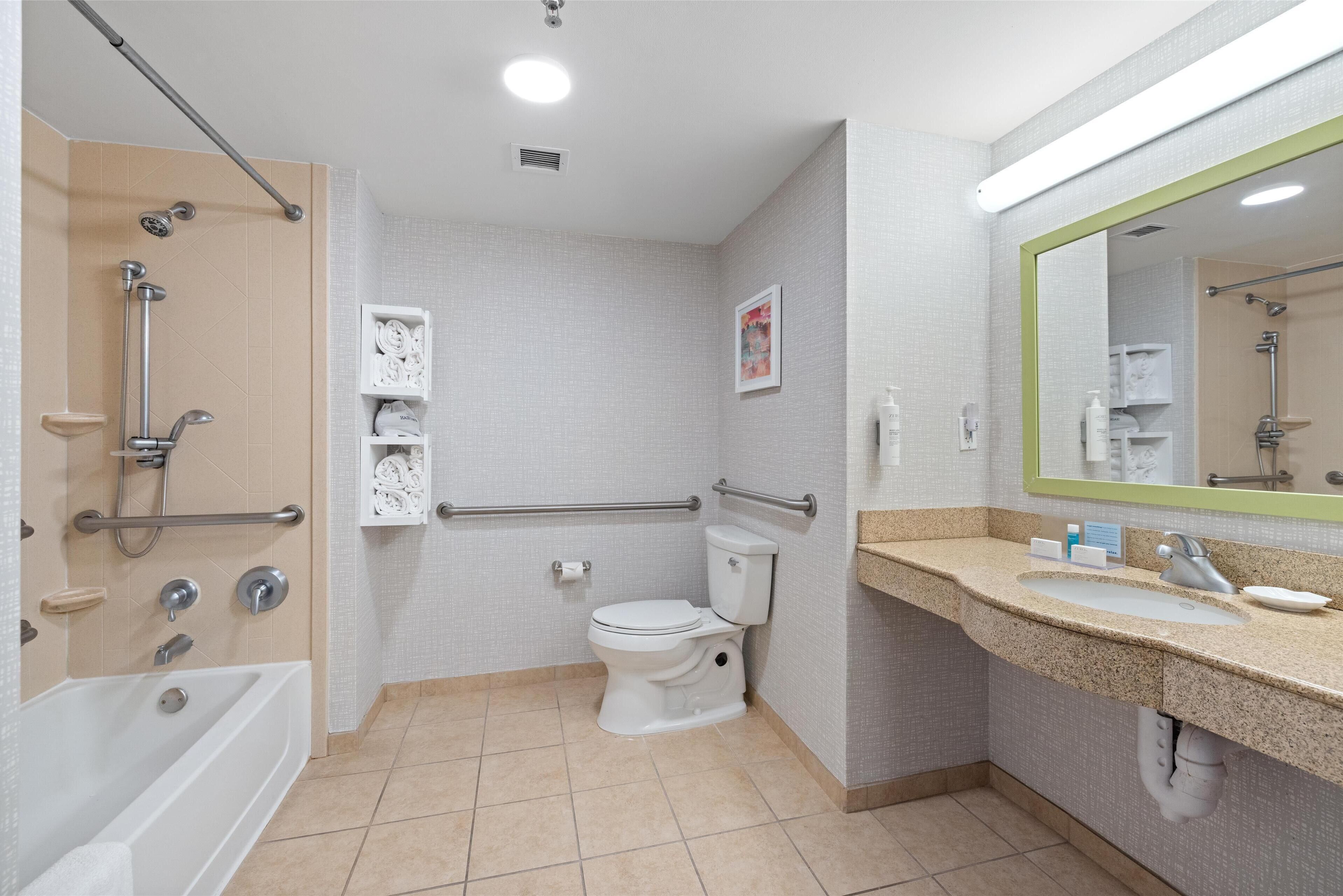 Een moderne badkamer met een bad, toilet en wastafel.