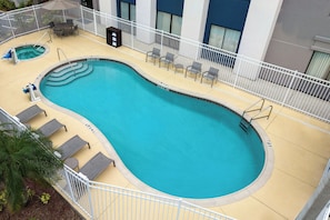 A swimming pool with a white fence, lounge chairs, and a small hot tub. - Springhill Suites by Marriott Tampa Brandon (Tampa)