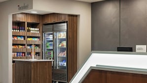 A hotel minibar with various snacks, beverages, and a refrigerator. - Springhill Suites by Marriott Tampa Brandon (Tampa)