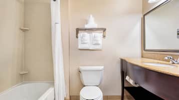 Un baño con bañera, inodoro y lavamanos.