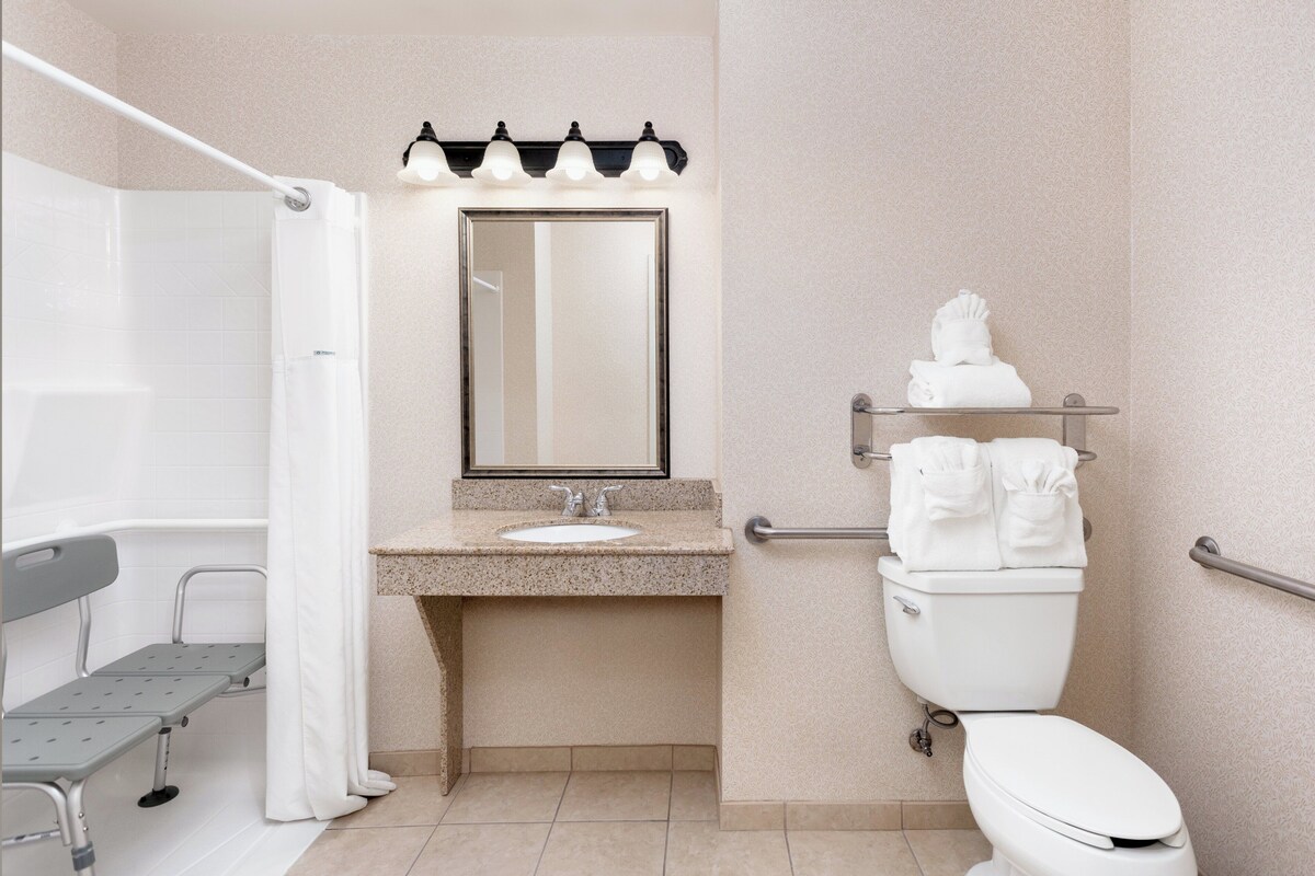 Une salle de bain équipée d’une douche, d’un lavabo, de toilettes et d’un banc.