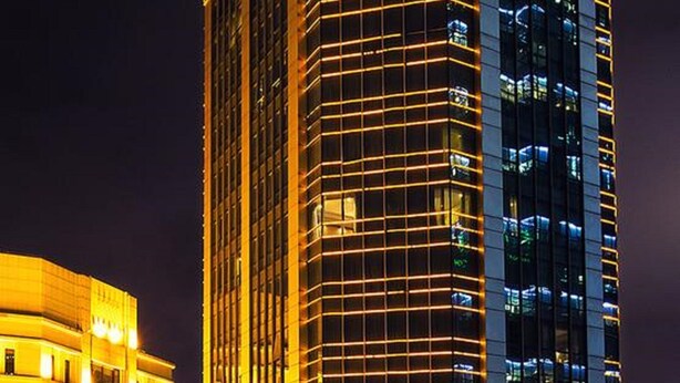 Un hôtel de grande hauteur au design moderne, avec une enseigne bien visible pour Howard Johnson et une autre pour China Youth.