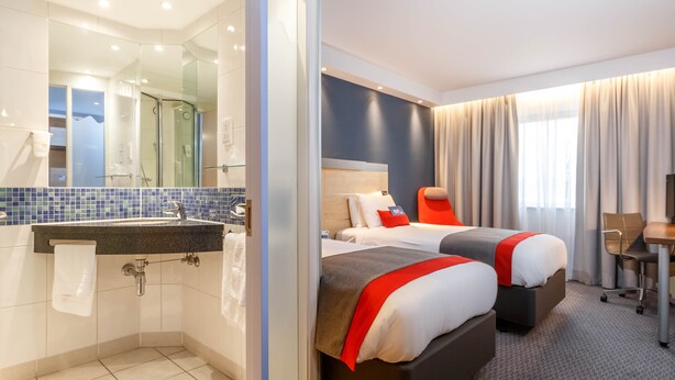 A hotel room with a bathroom, two beds, a desk, and a chair. - Holiday Inn Express Walsall M6J10 by IHG (Walsall)