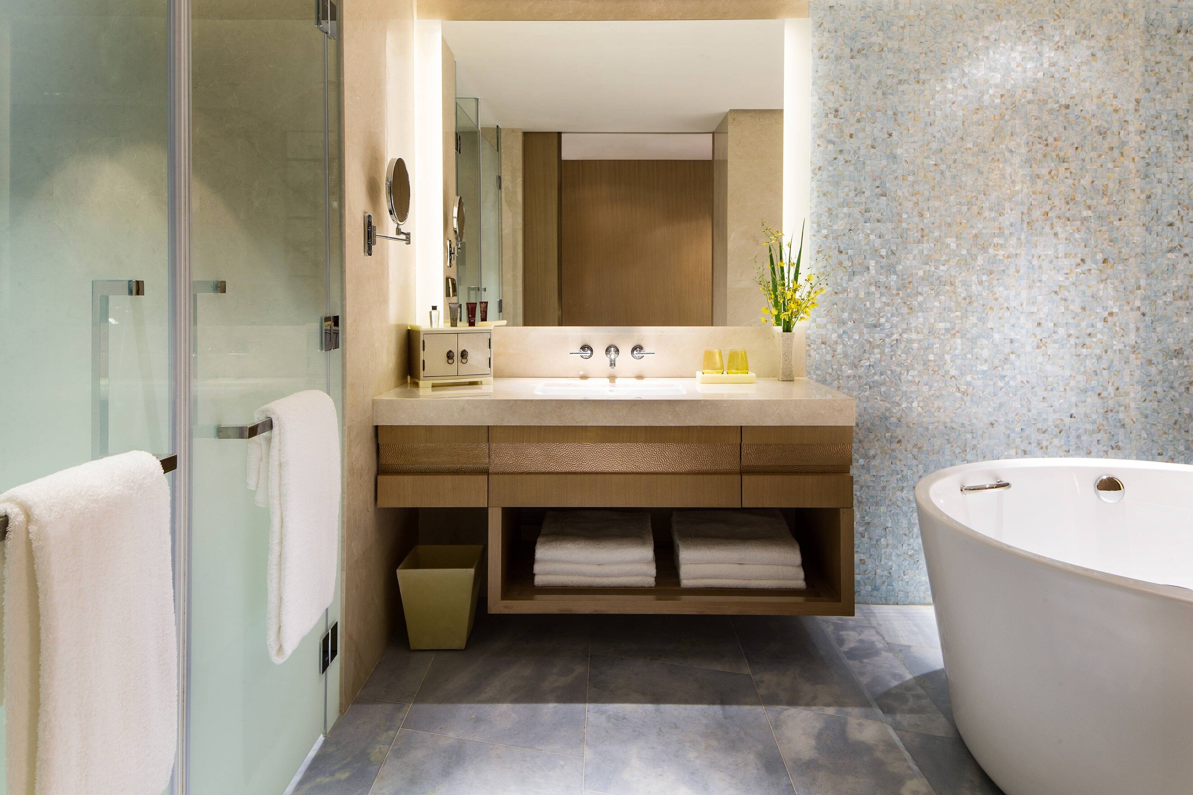 A modern bathroom with a glass-enclosed shower, a freestanding bathtub, and a vanity with a mirror and sink.