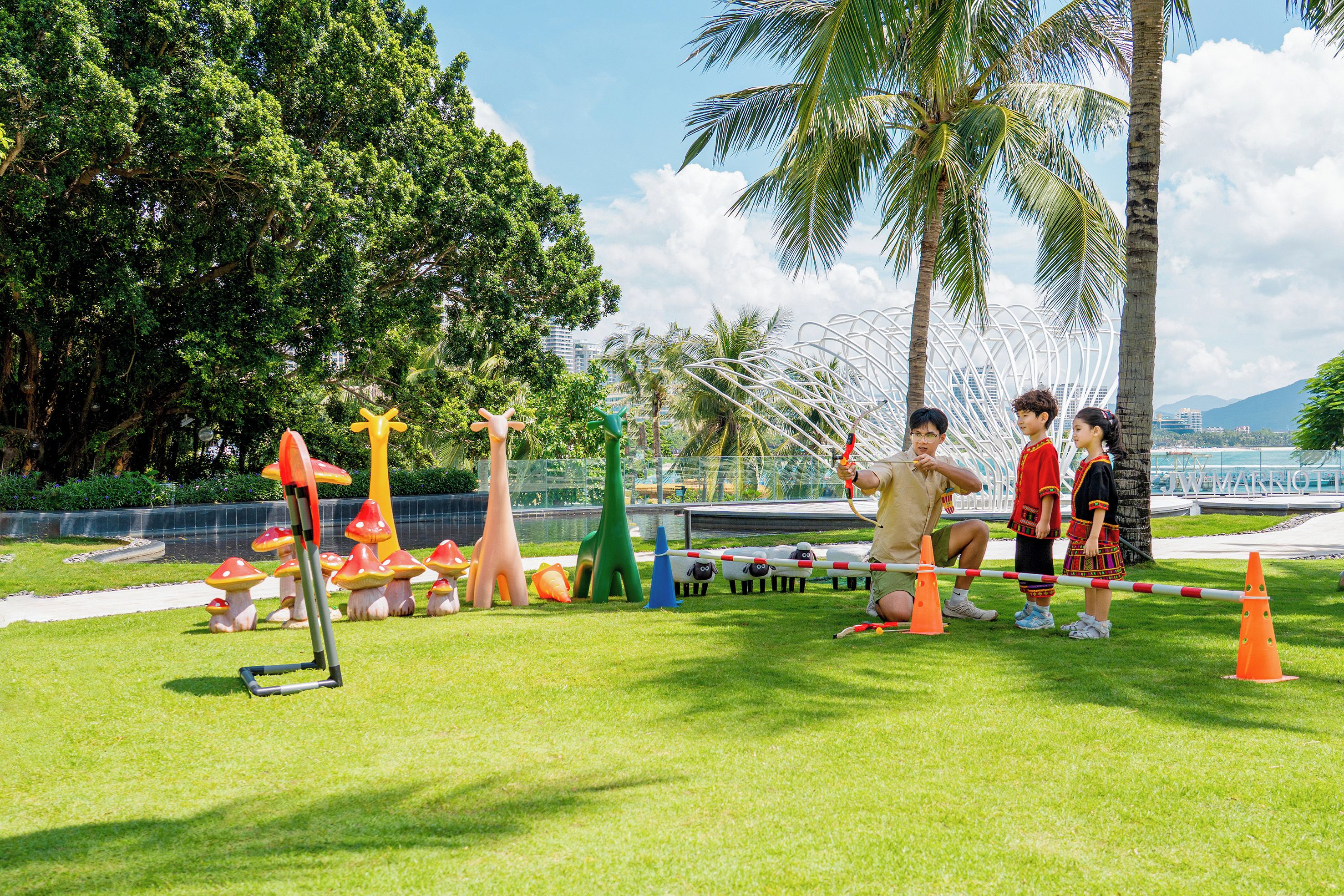 A group of people engaging in an outdoor activity with various colorful obstacles and a clear sky.
