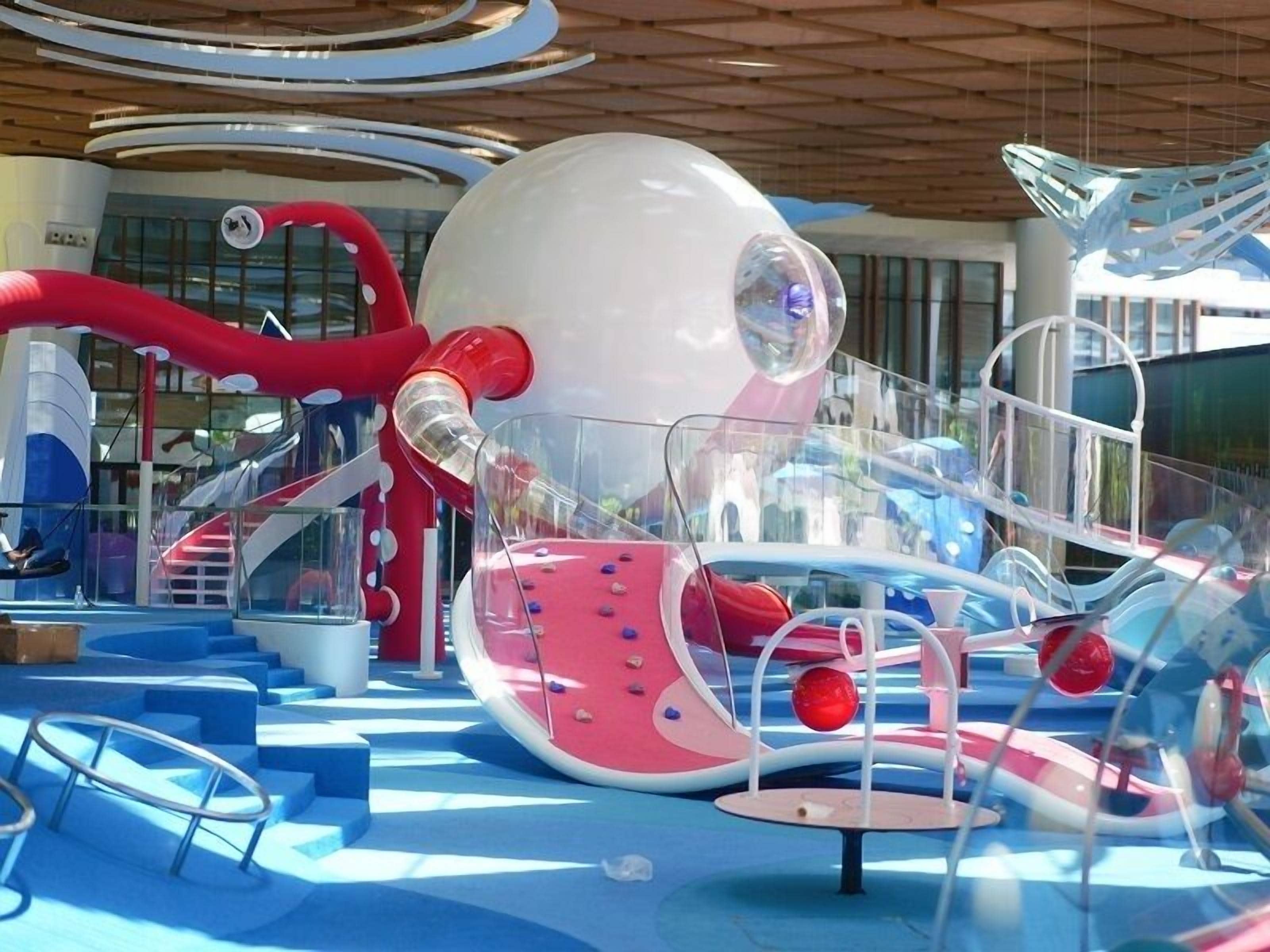 A children's play area with colorful slides and climbing structures.