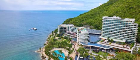 Un resort con varias construcciones, piscina y vista al océano.