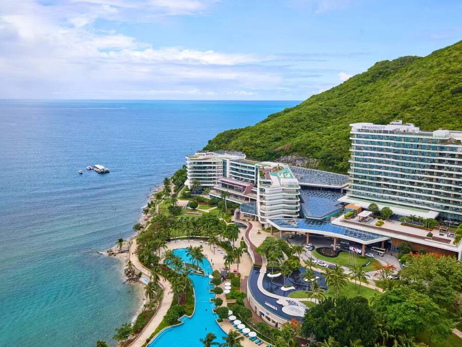 Un resort con varias construcciones, piscina y vista al océano.