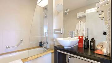 A modern bathroom with a bathtub, a sink, and a mirror.
