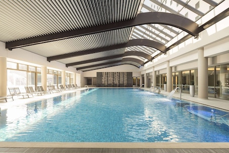 Indoor pool, seasonal outdoor pool, sun loungers. Ramada Plaza by Wyndham Bucharest Convention Center