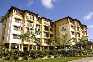 Un hotel de varios pisos con balcones, una señal que indica que es un hotel y banderas.