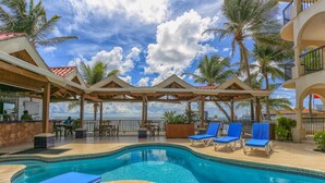 A pool area with lounge chairs and a view of the ocean. - Sunbreeze Suites (San Pedro)