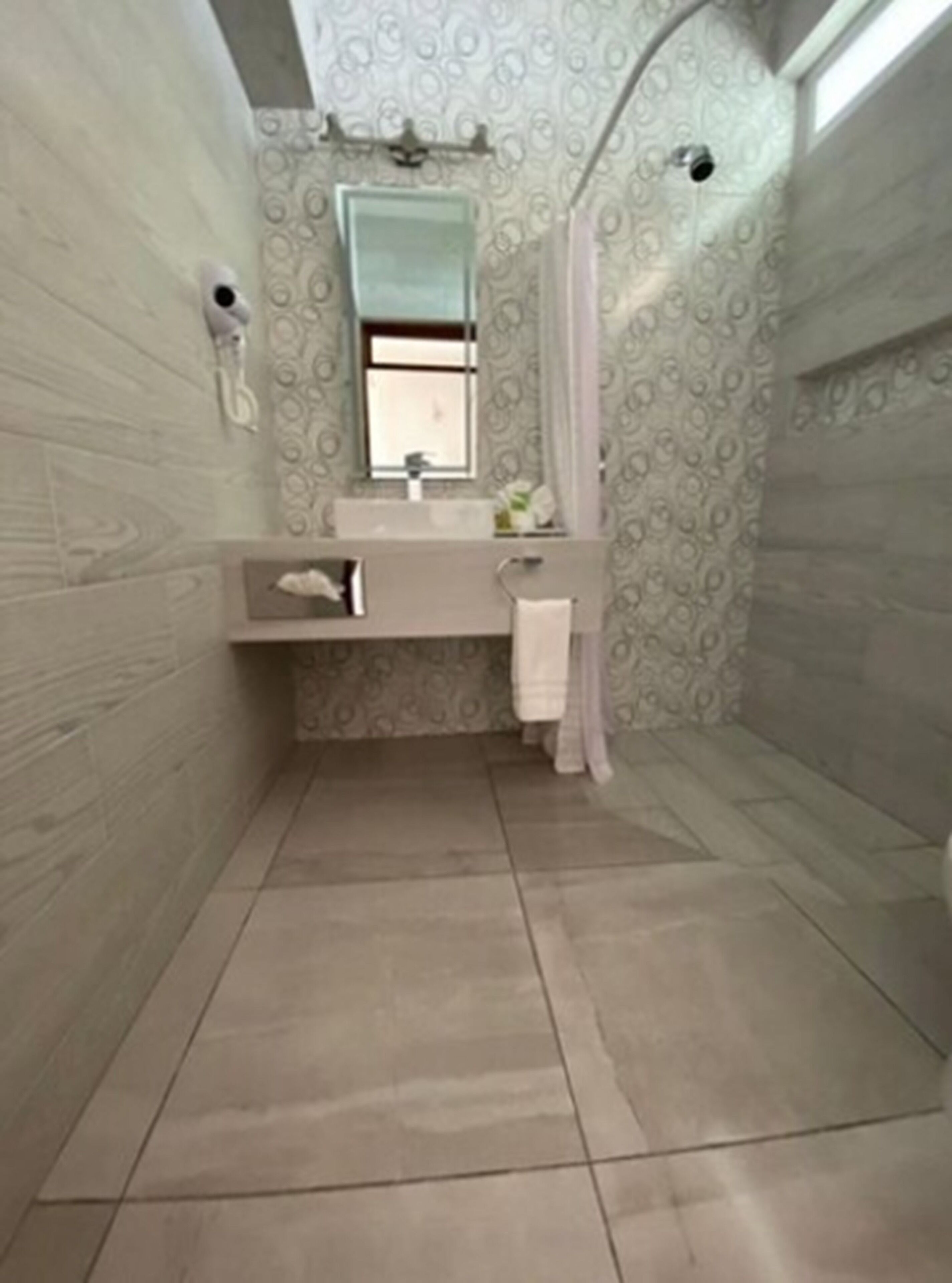 A bathroom with a shower, a sink, and a mirror.