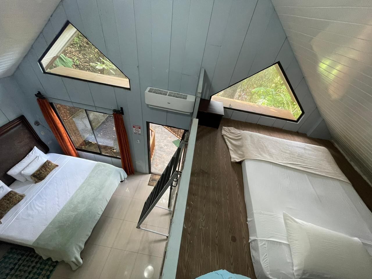 A room with two beds, a window, and a ceiling fan.