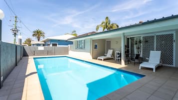 Una piscina al aire libre, tumbonas