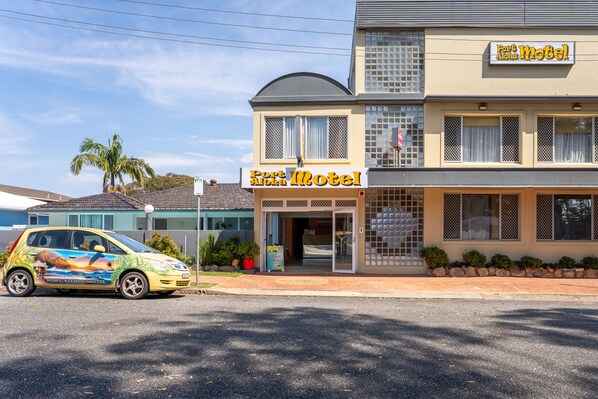 A motel with a sign reading "Port of Hope Motel" and a car parked in front. - Port Aloha Motel (Port Macquarie)
