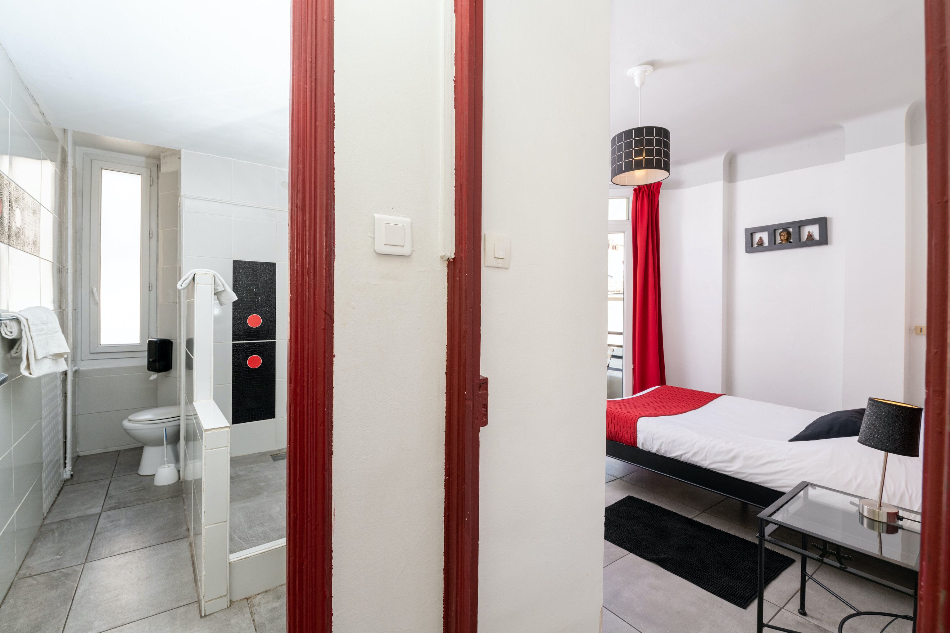 Una habitación de hotel moderna con cama, mesita de noche y baño completo.