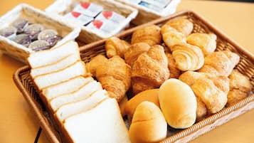 Ein Korb aus Weidengeflecht, gefüllt mit verschiedenen Backwaren und Brotscheiben.