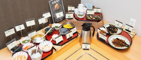 Una mesa de buffet con diversos platos y cubiertos.
