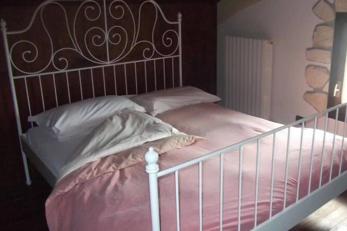 A single bed with a metal headboard and white bedding.