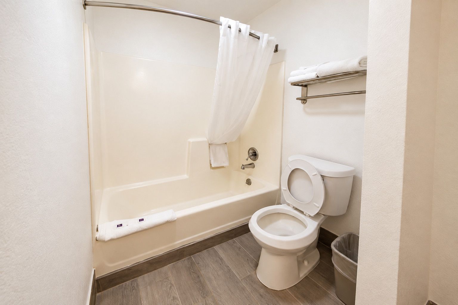 Une salle de bain avec une baignoire, des toilettes et un rideau de douche.
