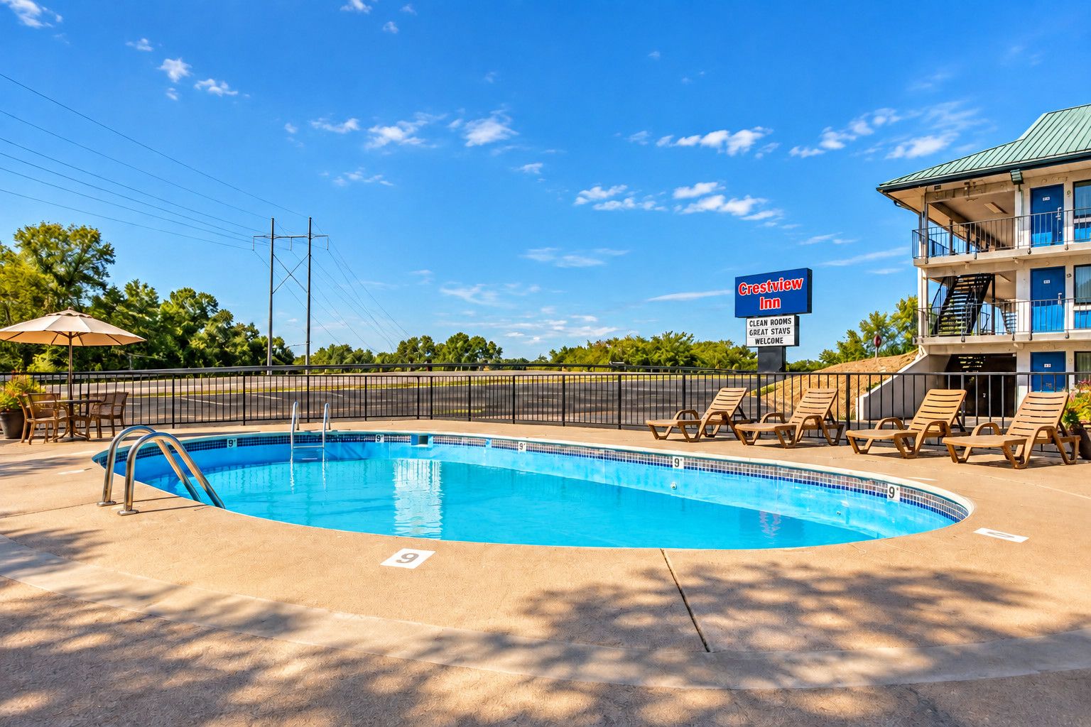 A swimming pool with lounge chairs and a Crestview Inn sign.