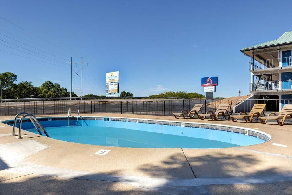 Una piscina con sillas de descanso y una torre de salvavidas.