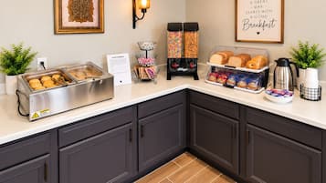 Una barra de desayuno con diferentes alimentos y una máquina de café.