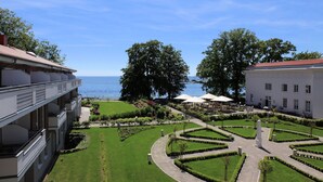 Un patio con vistas al mar, rodeado de edificios con balcones y un jardín bien cuidado.