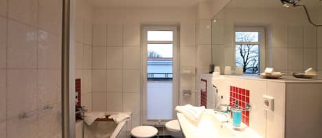 A modern bathroom with a bathtub, toilet, and sink.