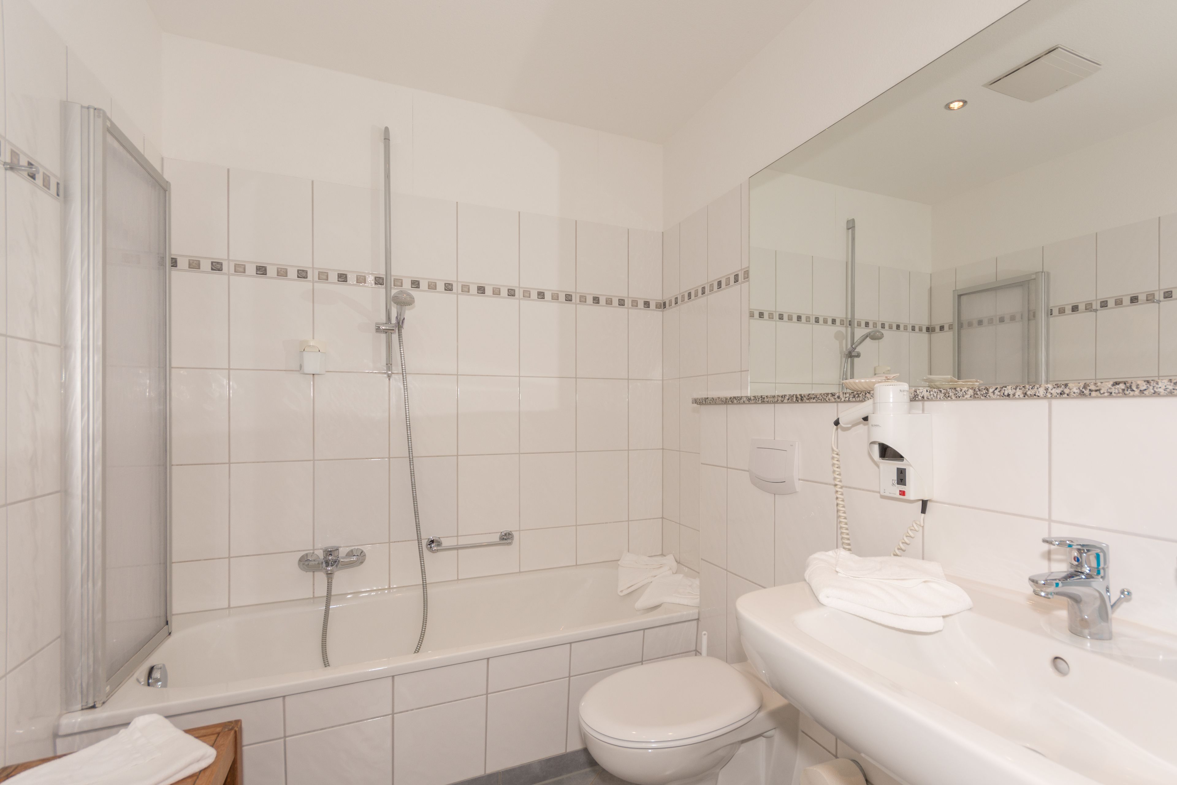 A bathroom with a bathtub, toilet, and sink.