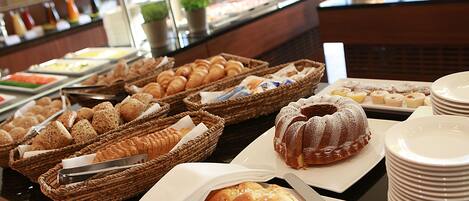 A buffet with various baked goods and pastries.