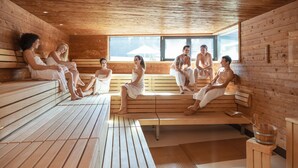 A wooden sauna with benches and a large window. - Thermenhotel Karawankenhof (Villach)