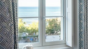 A window with a view of the sea and a parking area. - Hôtel de L'Océan et Restaurant - Coeur de Ville (Biarritz)