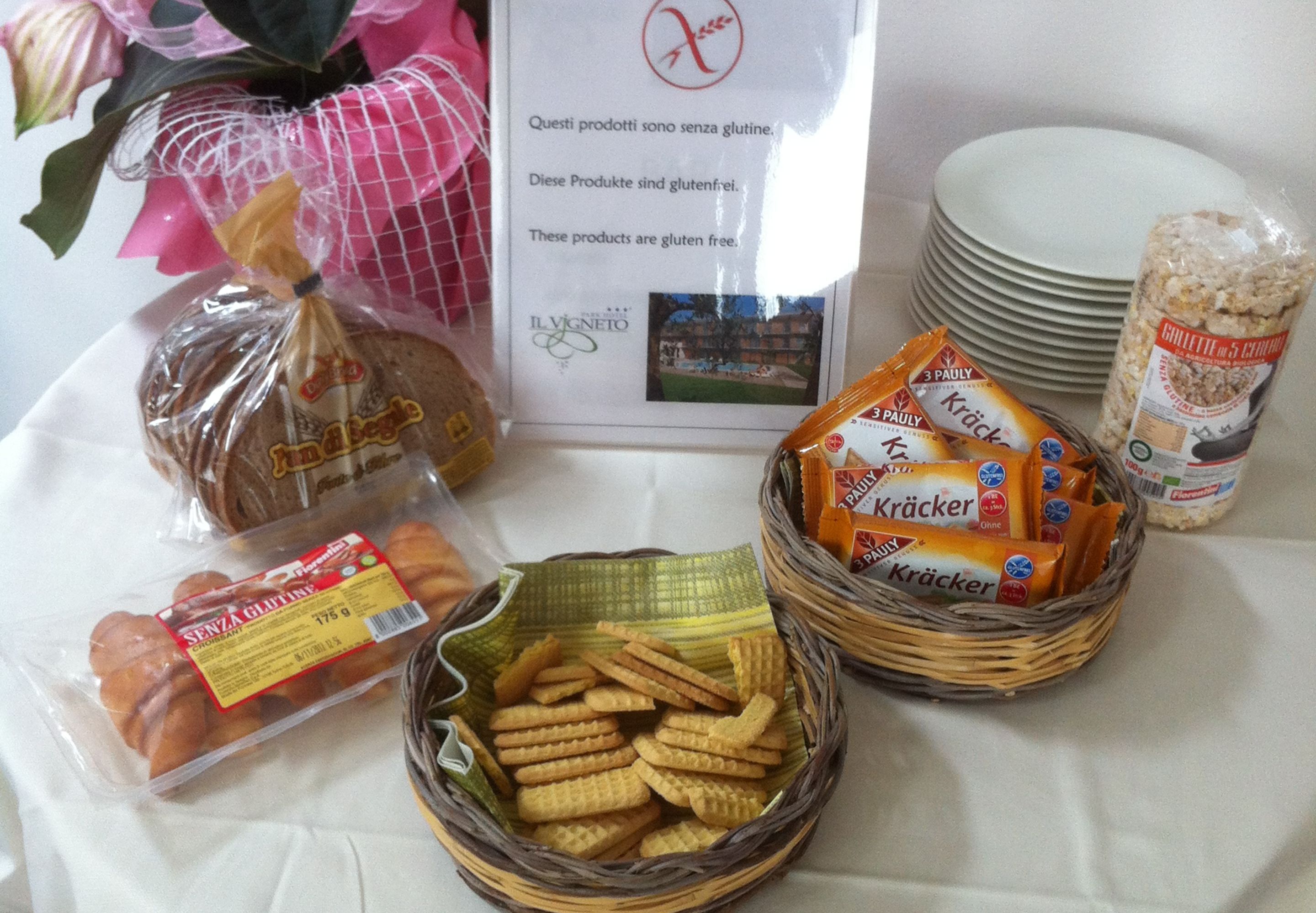 A table with various food items including bread, crackers, and a sign indicating gluten-free products.