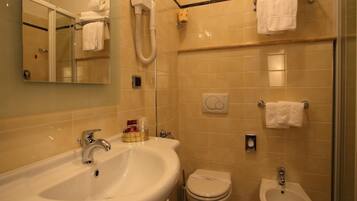 Un bagno con lavandino, WC, bidet e specchio.