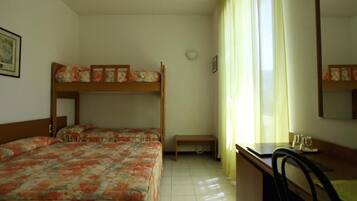A room with two bunk beds, a desk, a chair, and a window with curtains.