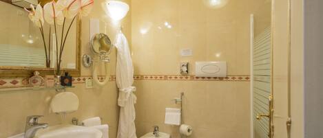 A bathroom with a sink, bidet, toilet, and a mirror.