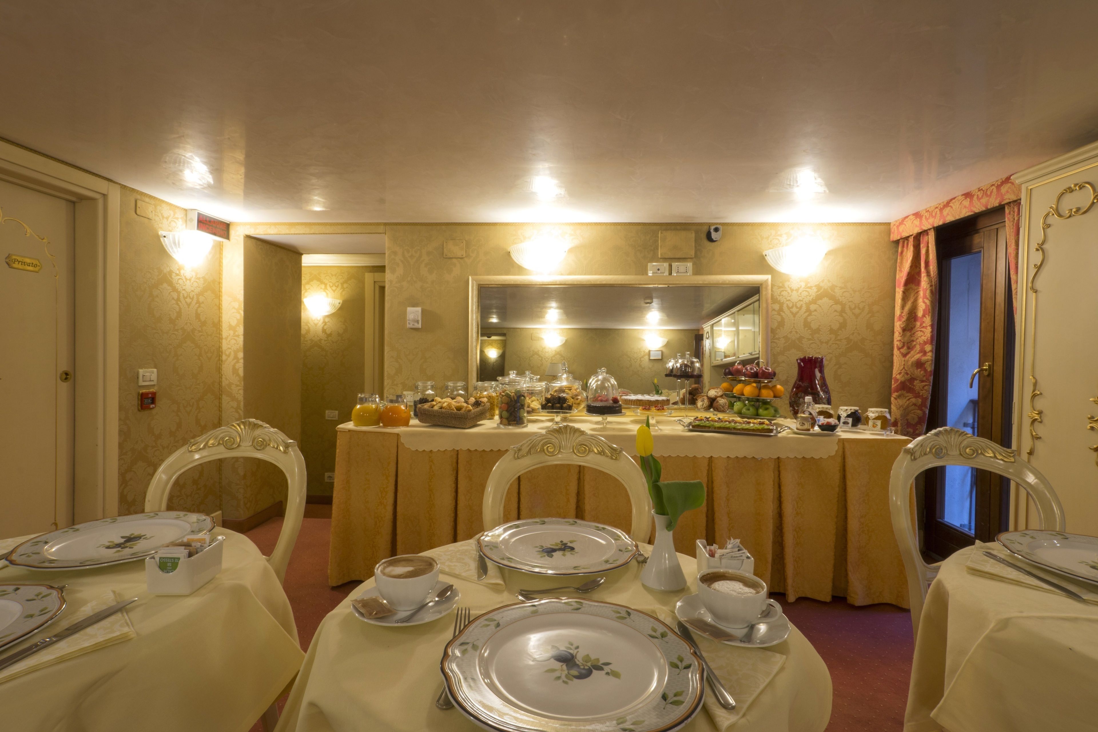 A dining area with tables set for breakfast, featuring plates, cups, and cutlery.