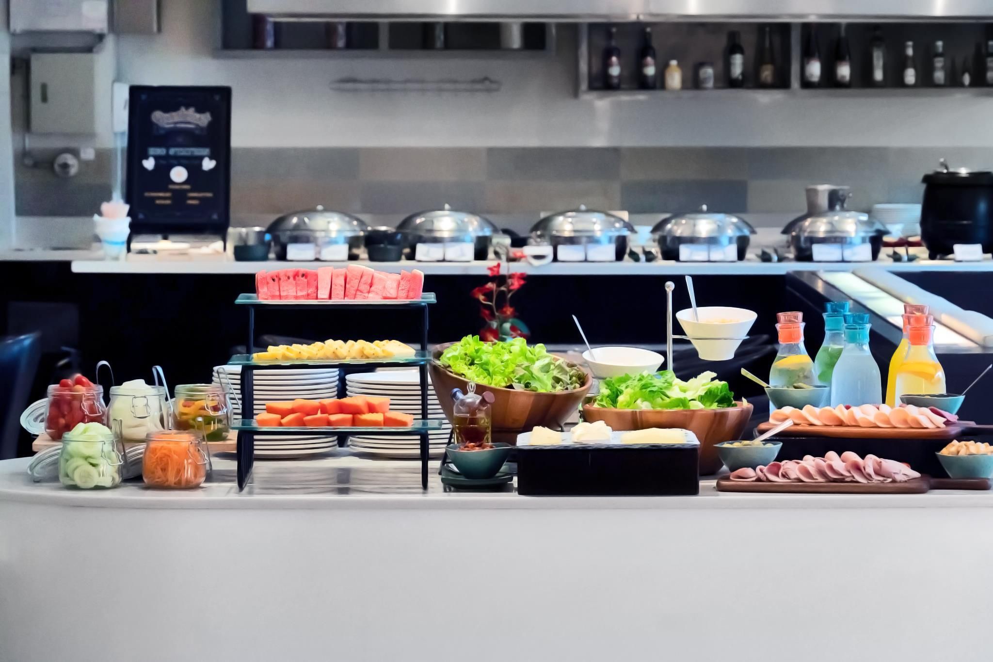 Disposição de buffet com diversos alimentos e acompanhamentos.
