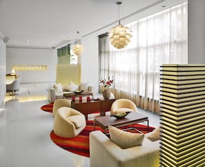 A modern hotel lobby with a sofa set, a coffee table, and a decorative vase. - NH Bangkok Asoke (Bangkok)