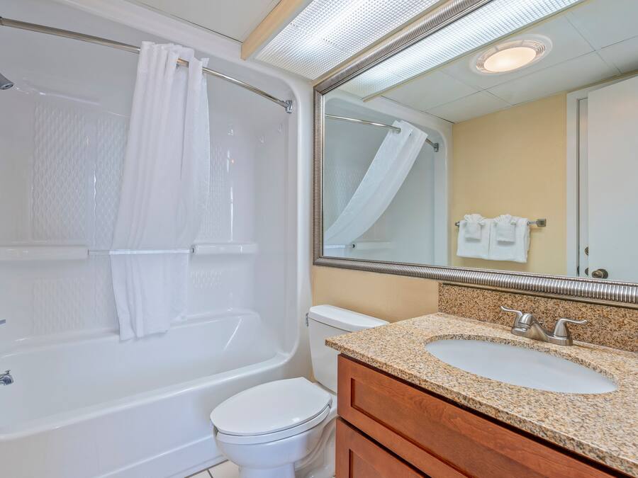 A bathroom with a bathtub, toilet, and vanity with a sink.