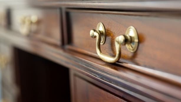 A close-up of a wooden dresser with brass handles. - Schlosshotel Ralswiek (Ralswiek)