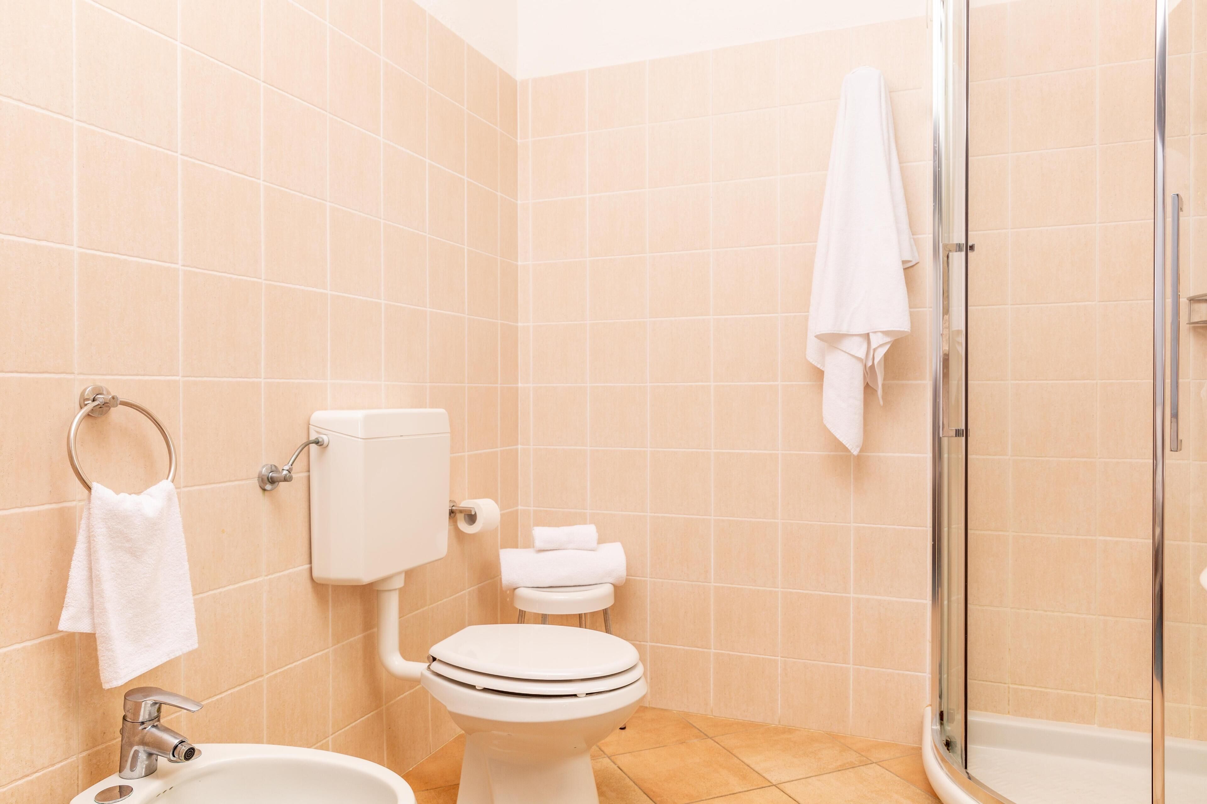 A bathroom with a toilet, sink, and shower.