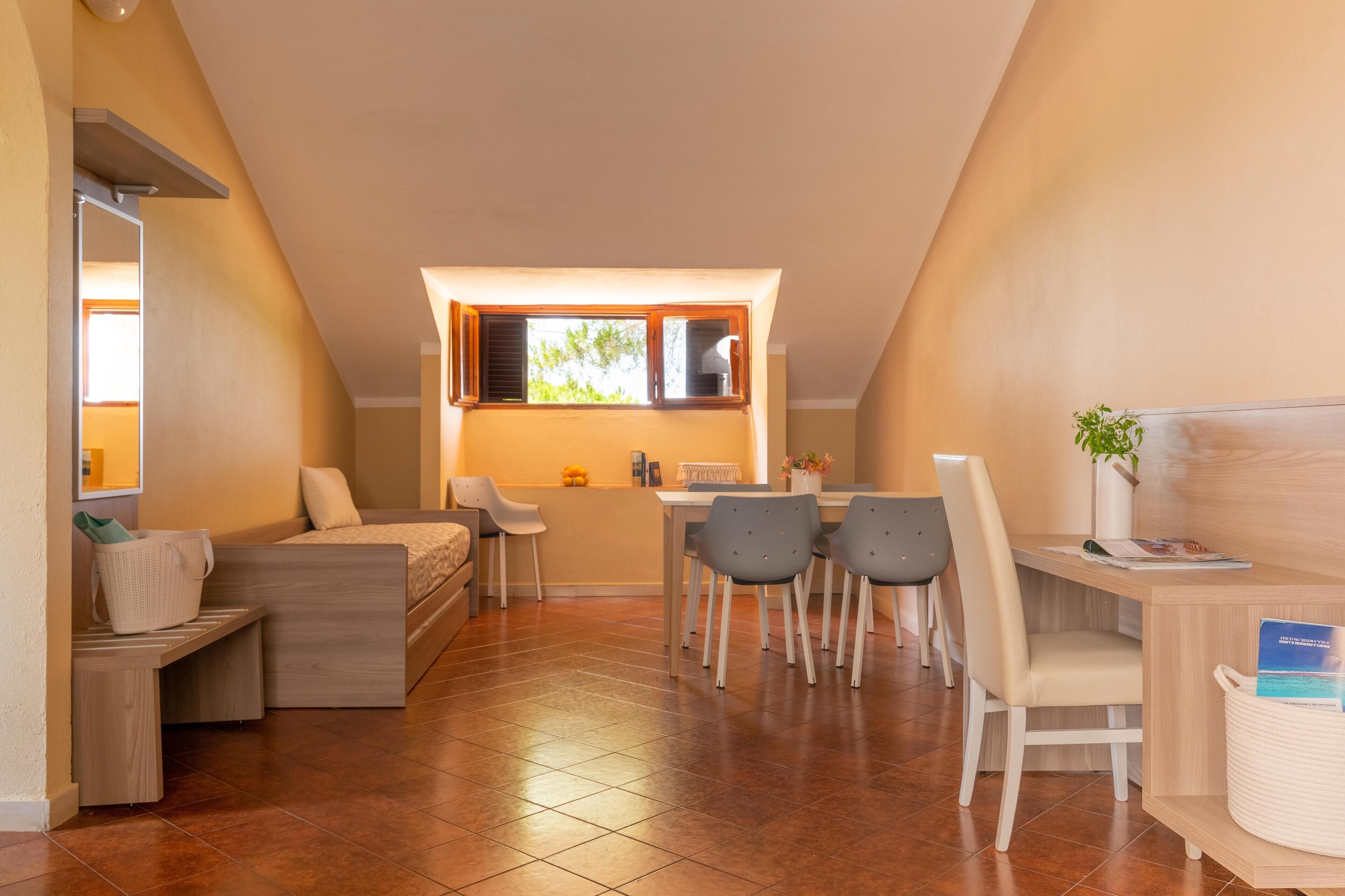 Ein modernes, kompaktes Wohnzimmer mit Essbereich, Küchenzeile und einer gemütlichen Sitzecke.