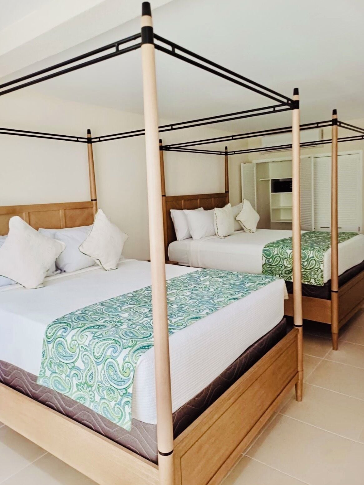 A four-poster bed with a wooden frame and white bedding.