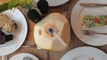 Een ontbijtsetting met borden eten, bestek en een plant.