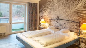Un lit bien fait, avec du linge de lit blanc, une tête de lit en métal et deux lampes de chevet.