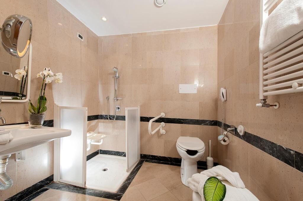 Un baño moderno con ducha, inodoro y lavamanos.